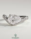 Kynora CJ 2ct pear-shaped diamond solitaire engagement ring with bead-set pave wave band in east-west setting.