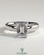 Kynora CJ 2ct emerald claw solitaire engagement ring with cigar band and hidden halo, showcasing a sparkling emerald centerpiece.