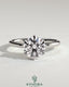Kynora CJ 2ct round claw solitaire engagement ring with wrap-around hidden halo in polished gold setting.