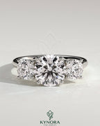 Kynora CJ 2ct round claw trilogy engagement ring with round side stones and trellis gallery setting, sparkling and elegant.