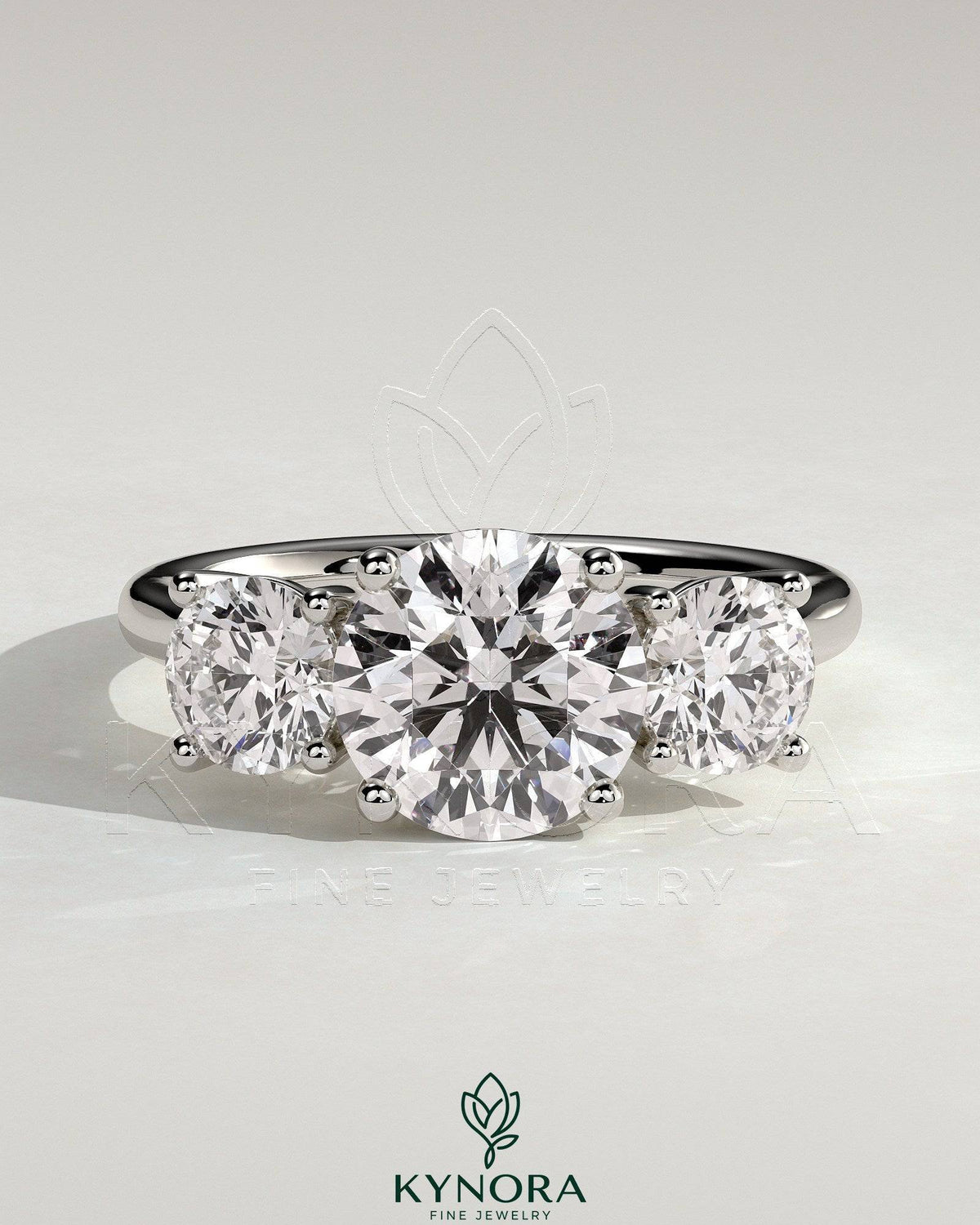 Kynora CJ 2ct round claw trilogy engagement ring with round side stones and trellis gallery setting, sparkling and elegant.