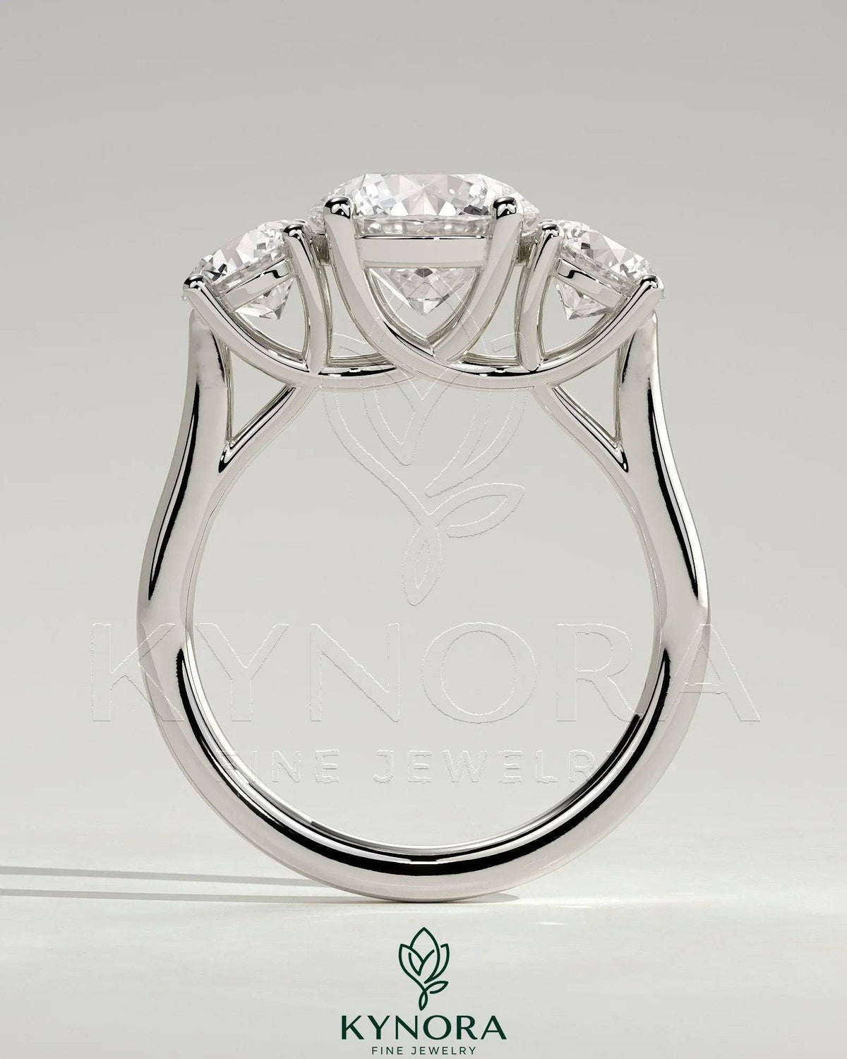 Kynora CJ 2ct round claw trilogy engagement ring with side stones and trellis gallery design, showcasing sparkling diamonds.