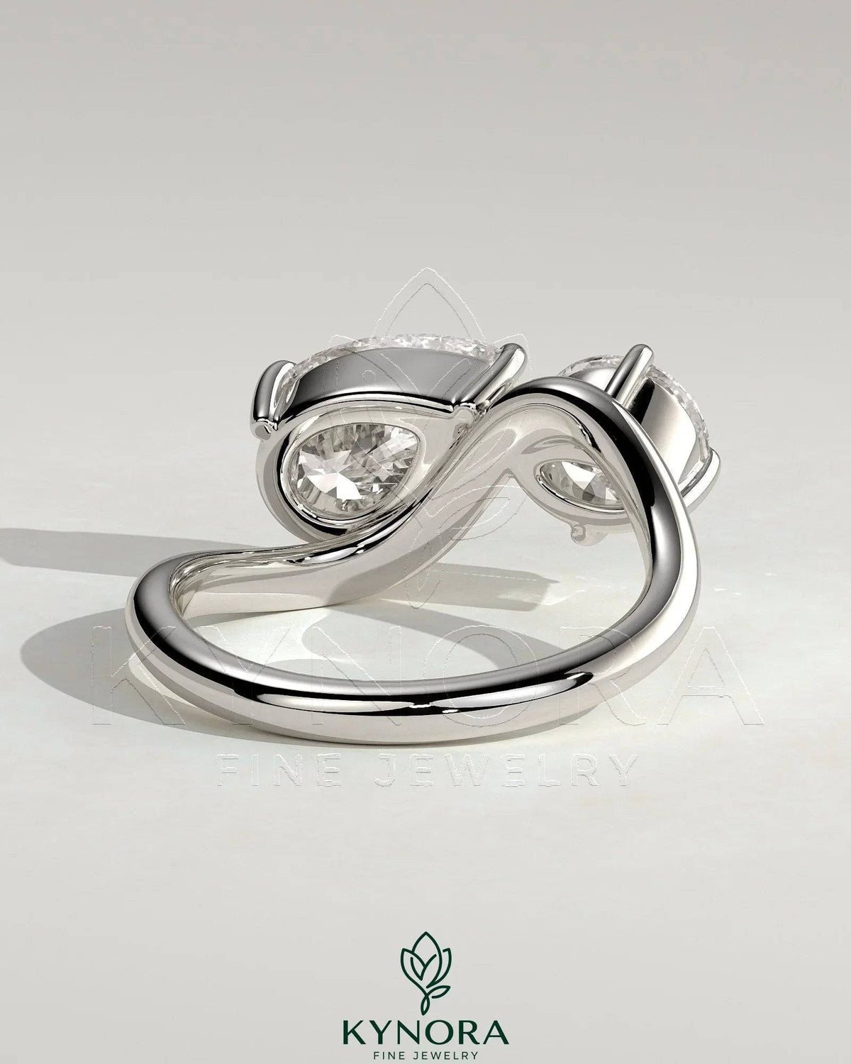 Kynora CJ Toi et Moi engagement ring with 1ct round and 1.5ct pear-shaped diamonds on a wave band.