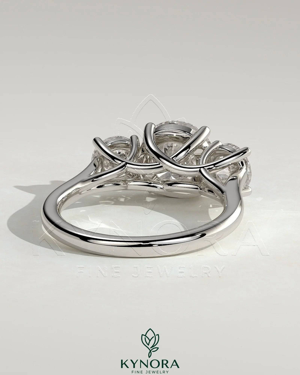 Kynora CJ 2ct round claw trilogy engagement ring with round side stones and trellis gallery design.