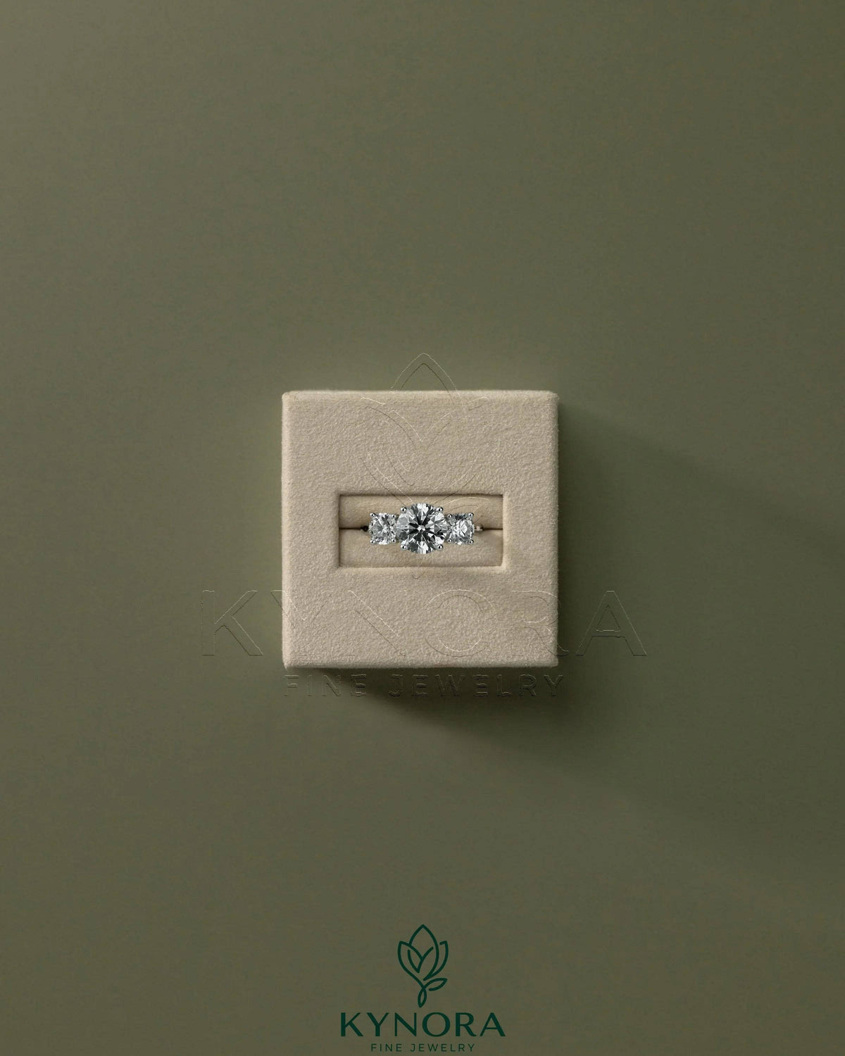 Kynora CJ 2ct round claw trilogy engagement ring with side stones and trellis gallery design, featuring a sparkling central diamond.