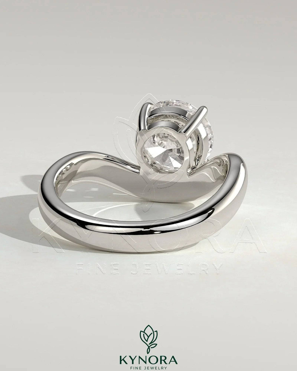 Kynora CJ 2ct round East-West claw solitaire engagement ring with wave band, showcasing a sparkling central diamond.
