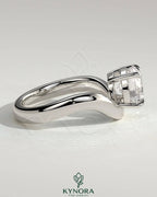 Kynora CJ 2ct round East-West claw solitaire engagement ring with wave band, showcasing a sparkling diamond and unique design.