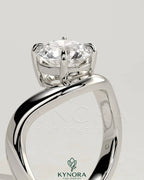 Kynora CJ 2ct round East-West claw solitaire engagement ring with wave band featuring a sparkling central diamond.
