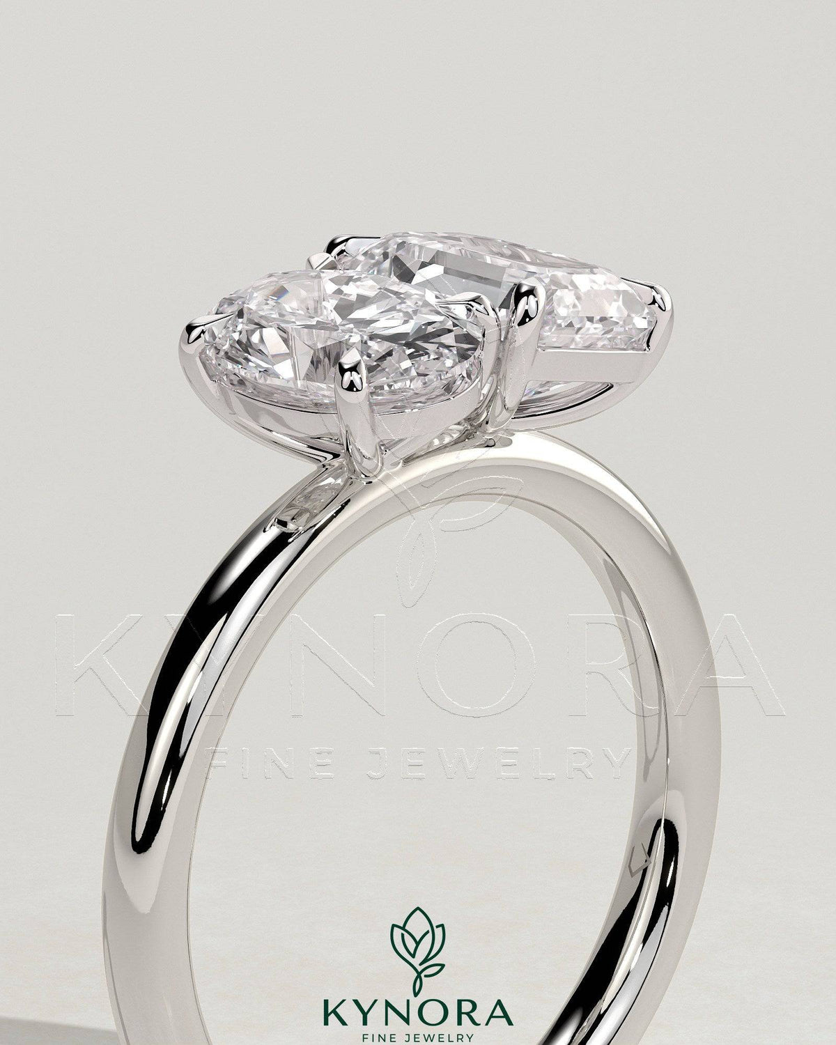 Kynora CJ Toi et Moi engagement ring featuring 1.05ct oval and 1.8ct emerald-cut diamonds, set in a delicate band.