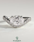 Kynora CJ 2ct oval claw solitaire engagement ring with bead set pave wave band and east-west setting, showcasing elegant jewelry design.