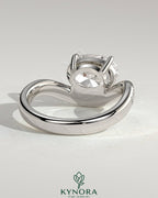 Kynora CJ 2ct oval claw solitaire engagement ring with bead-set pave wave band in east-west setting, showcasing sparkling diamond design.