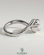 Kynora CJ 2ct elongated cushion east-west diamond engagement ring with bypass band and claw setting on a gold band.