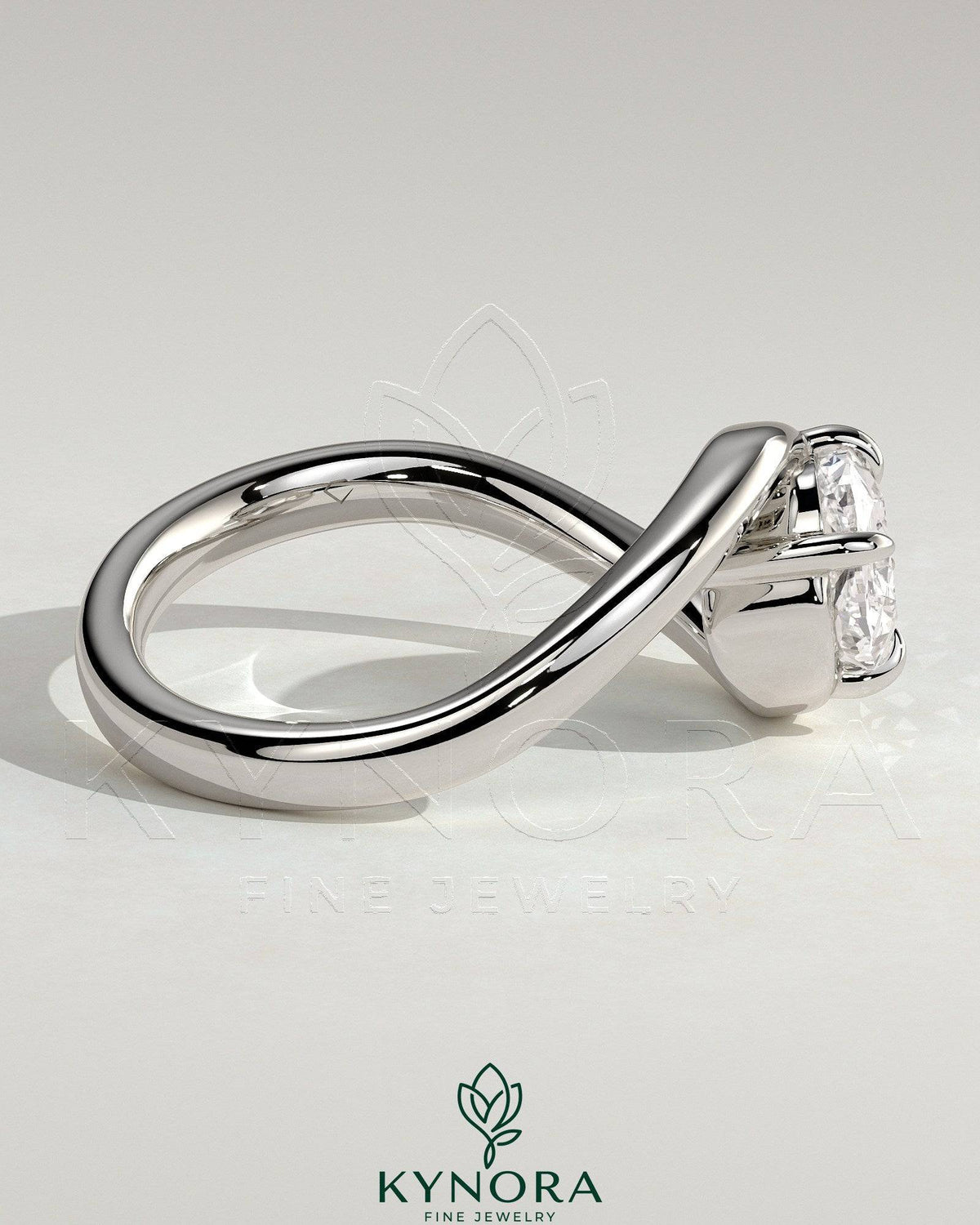 Kynora CJ 2ct elongated cushion east-west diamond engagement ring with bypass band and claw setting on a gold band.