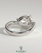 Kynora CJ 2ct pear-shaped diamond solitaire engagement ring with bead-set pave wave band in east-west setting.