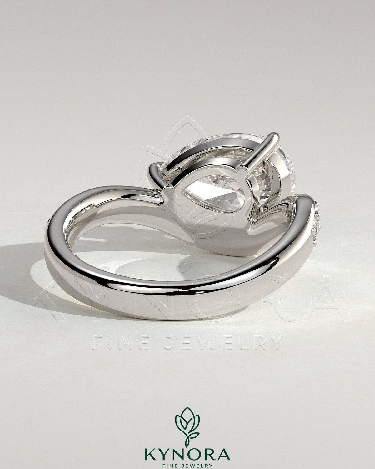 Kynora CJ 2ct pear-shaped diamond solitaire engagement ring with bead-set pave wave band in east-west setting.