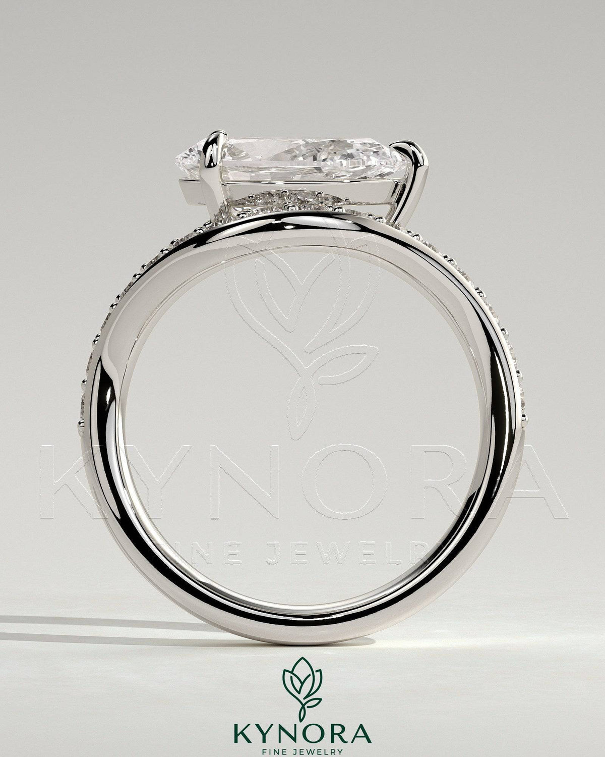 Kynora CJ 2ct pear-shaped diamond solitaire engagement ring with bead-set pave wave band and east-west setting.