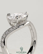 Kynora CJ 2ct pear-shaped diamond solitaire engagement ring with bead set pave wave band in east-west setting.
