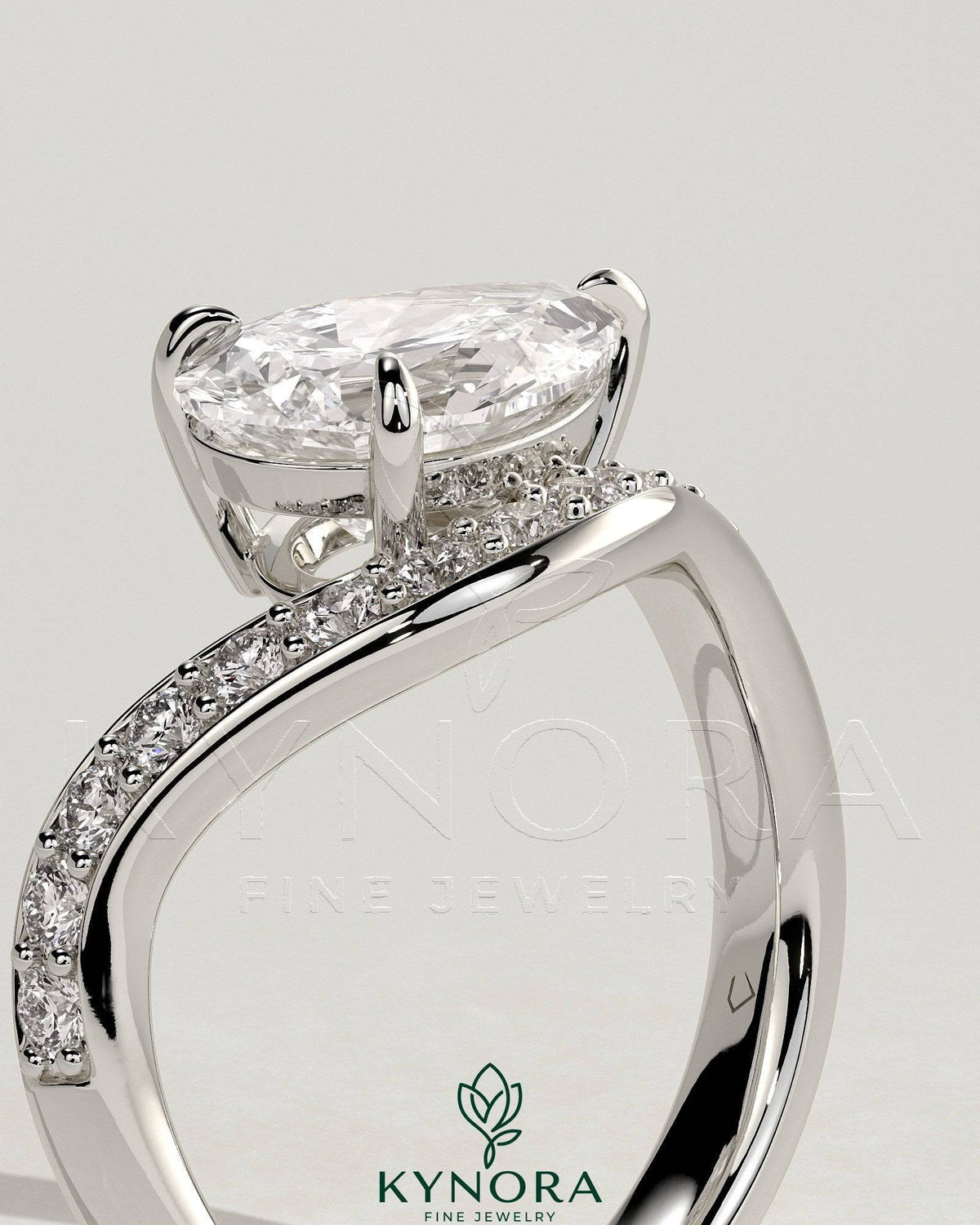 Kynora CJ 2ct pear-shaped diamond solitaire engagement ring with bead set pave wave band in east-west setting.