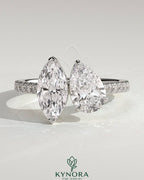 Kynora CJ Toi et Moi engagement ring with 1.5ct marquise and 1.8ct pear-shaped diamonds, pave band, cathedral setting.