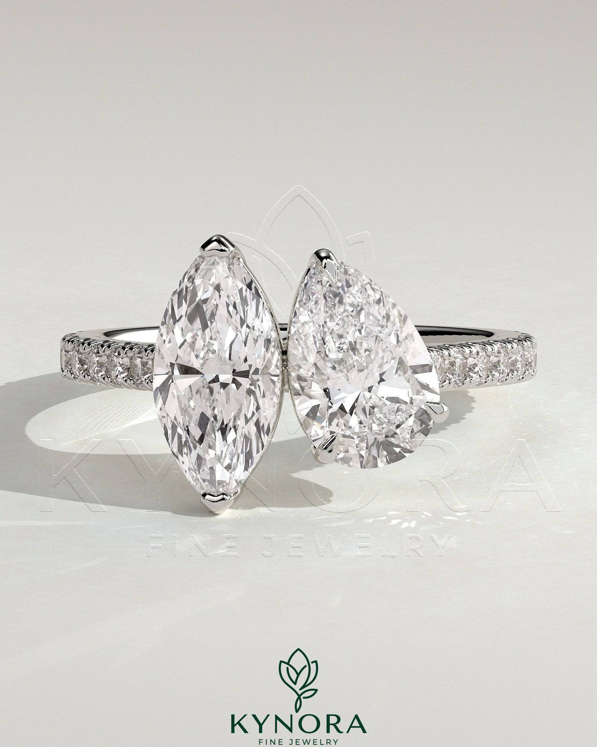 Kynora CJ Toi et Moi engagement ring with 1.5ct marquise and 1.8ct pear-shaped diamonds, pave band, cathedral setting.