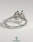 Kynora CJ Toi et Moi engagement ring with 1.5ct marquise and 1.8ct pear-shaped diamonds, pave band, cathedral high setting.