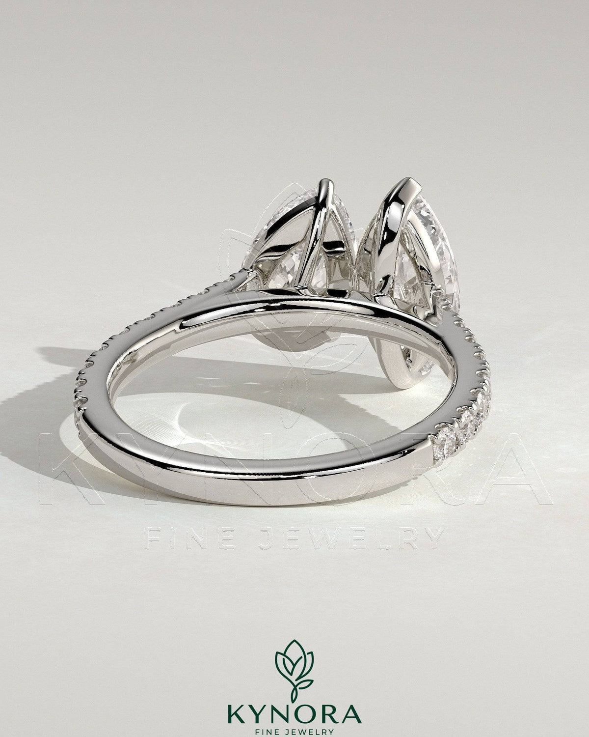 Kynora CJ Toi et Moi engagement ring with 1.5ct marquise and 1.8ct pear-shaped diamonds, pave band, cathedral high setting.