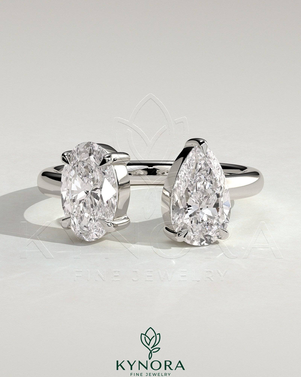 Kynora CJ Toi et Moi engagement ring with 1.23ct oval and 1.15ct pear-shaped diamonds on an open band. Imagen principal del producto