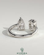 Kynora CJ Toi et Moi engagement ring featuring 1.23ct oval and 1.15ct pear-shaped diamonds with an open band design.