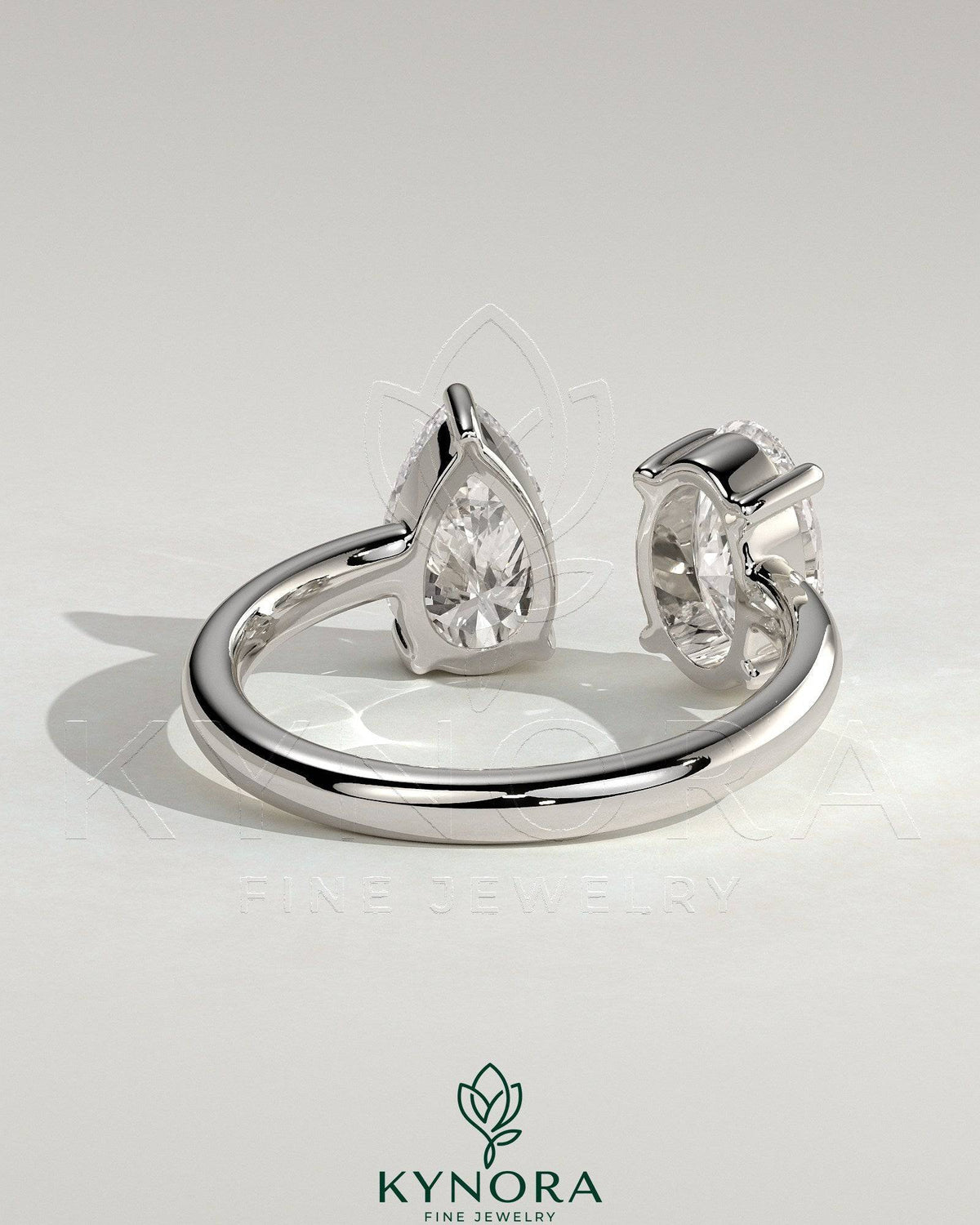 Kynora CJ Toi et Moi engagement ring featuring 1.23ct oval and 1.15ct pear-shaped diamonds with an open band design.