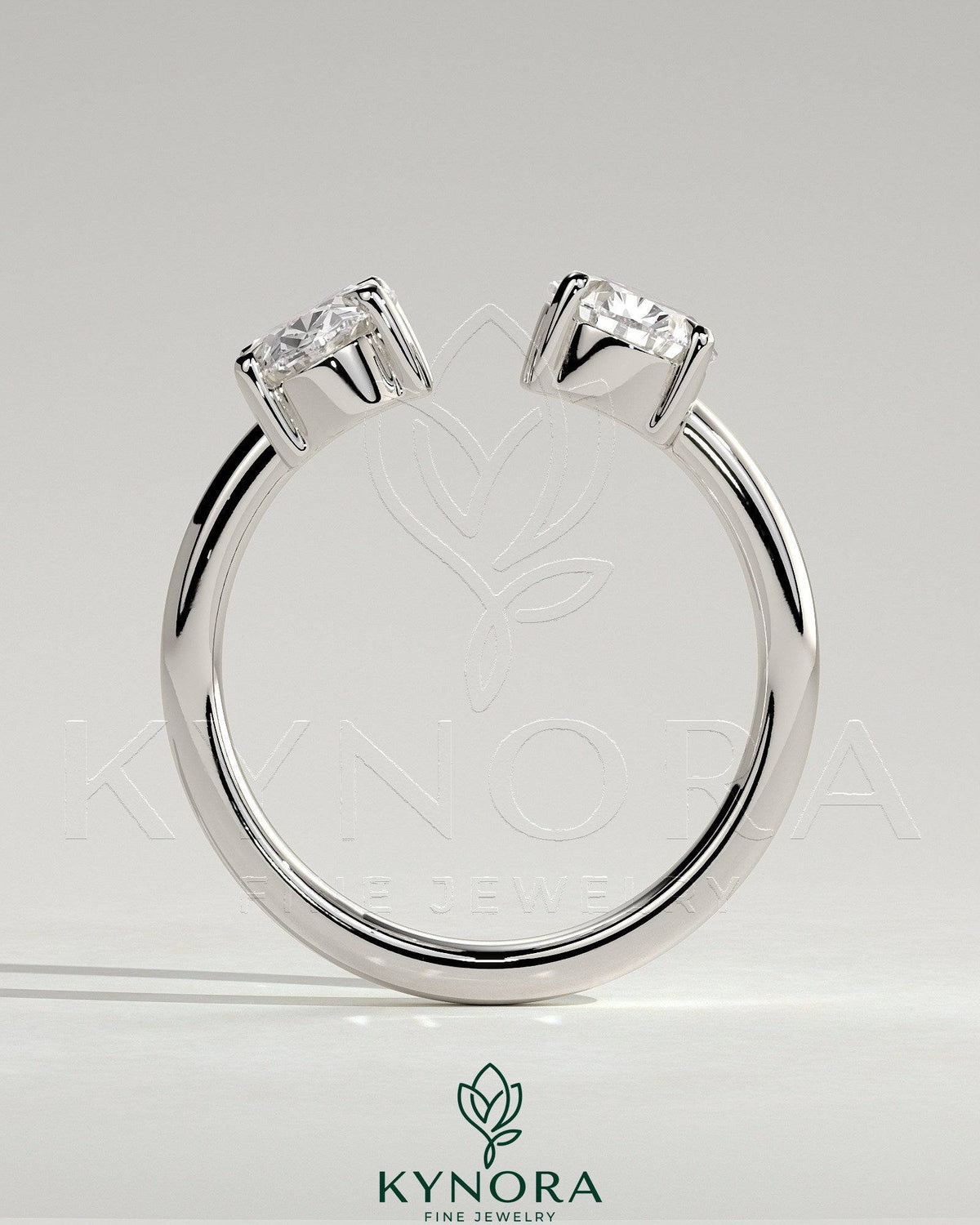 Kynora CJ Toi et Moi engagement ring featuring a 1.23ct oval and 1.15ct pear-shaped diamonds with open band design.