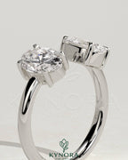 Kynora CJ Toi et Moi engagement ring with 1.23ct oval and 1.15ct pear-shaped diamonds on an open band, showcasing intricate design.