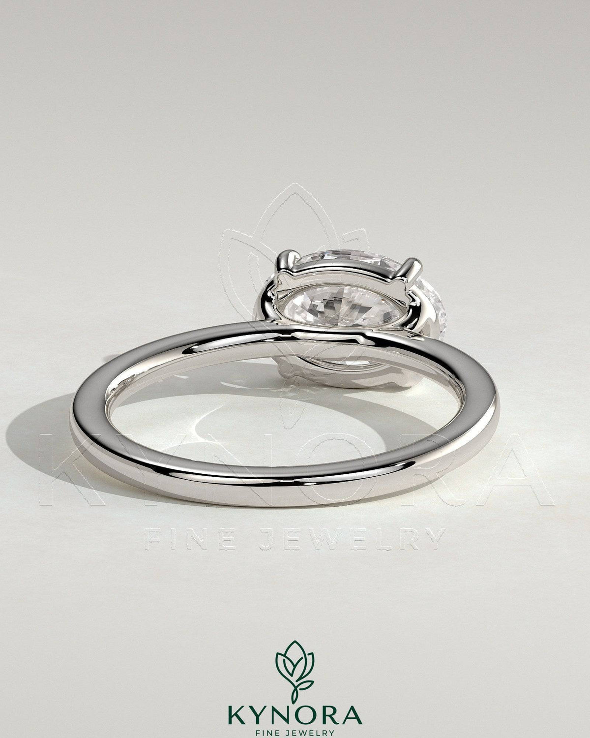 Oval east-west claw solitaire engagement ring by Kynora CJ with raised basket gallery and 2-carat diamond.