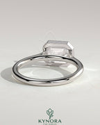 Kynora CJ emerald east-west bezel solitaire engagement ring with open cathedral high setting showcasing a 2-carat emerald gemstone.