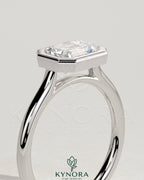 Kynora CJ 2ct emerald east-west bezel solitaire engagement ring with open cathedral high setting and intricate band details.