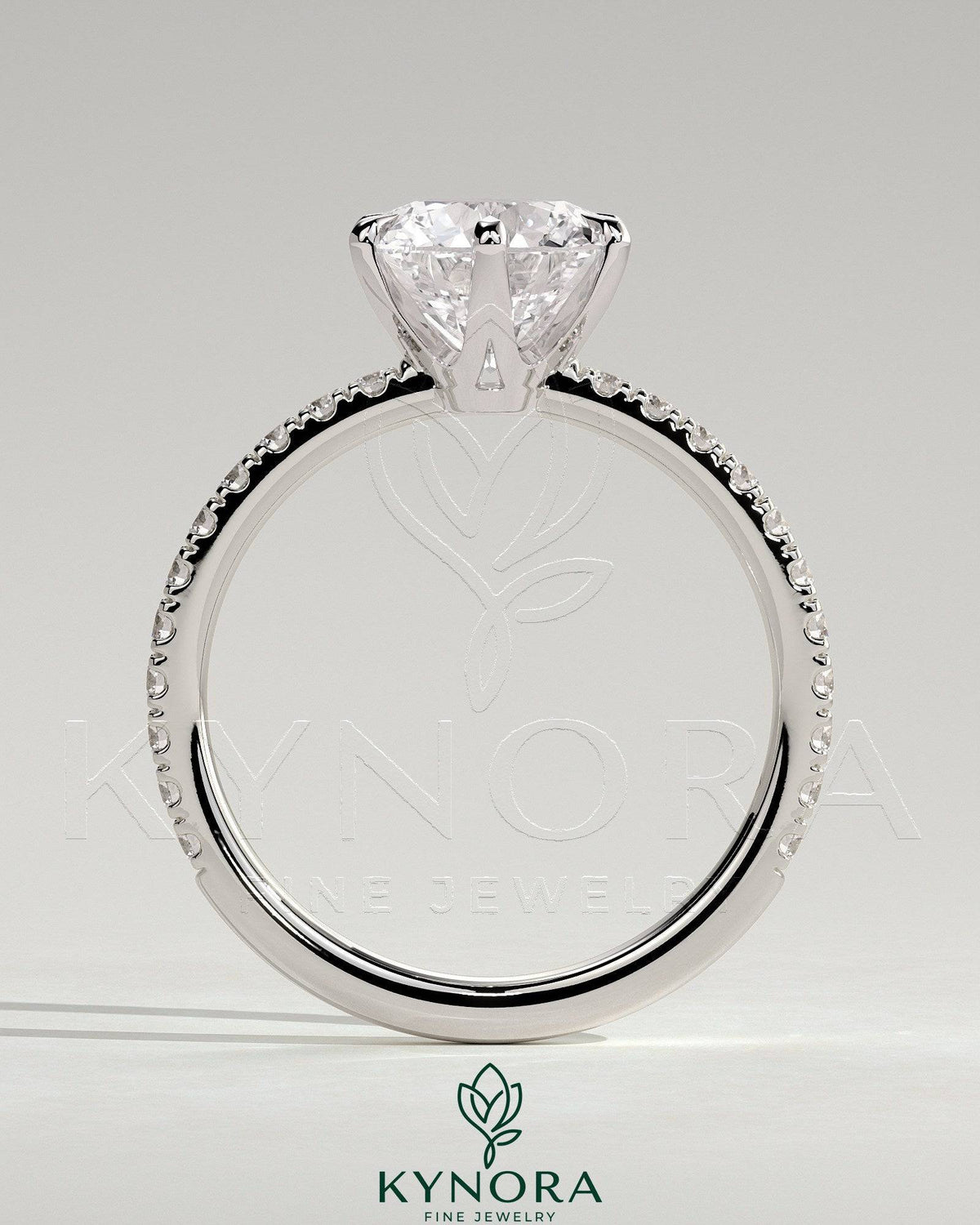Kynora CJ 2ct round claw solitaire engagement ring with crown gallery and pave band, showcasing elegant craftsmanship.