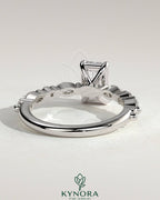 Kynora CJ 2ct emerald claw solitaire engagement ring with marquise and round accent stones, showcasing elegant jewelry design