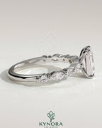 Kynora CJ 2ct emerald claw solitaire engagement ring with marquise and round accent stones, elegant and sparkling jewelry piece.