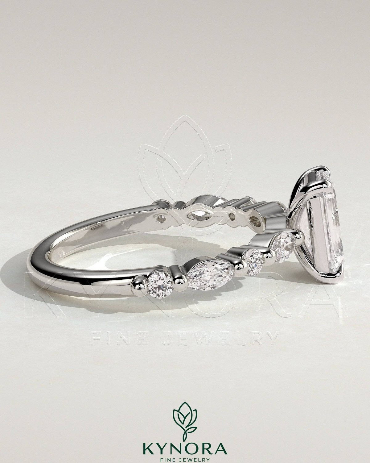 Kynora CJ 2ct emerald claw solitaire engagement ring with marquise and round accent stones, elegant and sparkling jewelry piece.