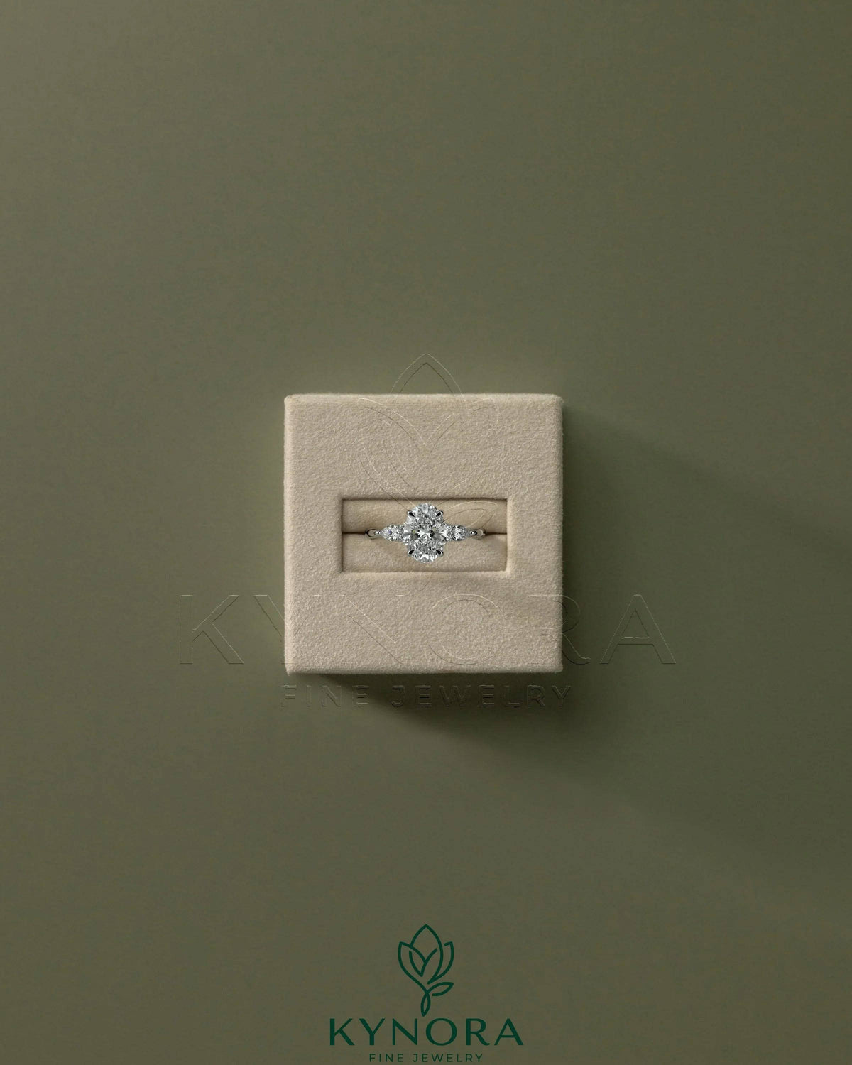 Kynora CJ 2ct oval claw solitaire engagement ring with pear accent stones and round shoulder stones, elegant three-stone design.