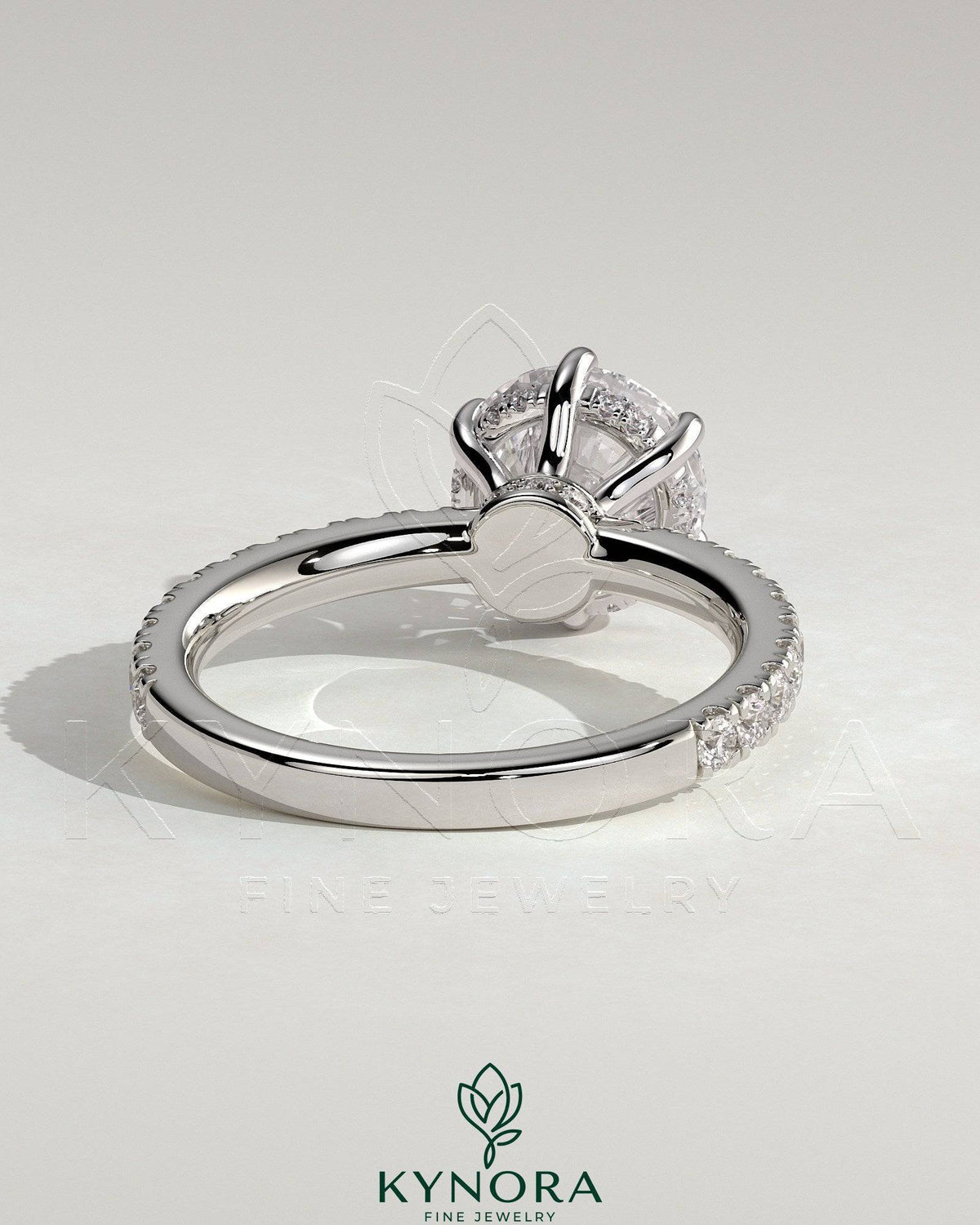 Kynora CJ 2ct round claw solitaire engagement ring with hidden halo, pave collar, and pave band showcasing sparkling jewelry design.