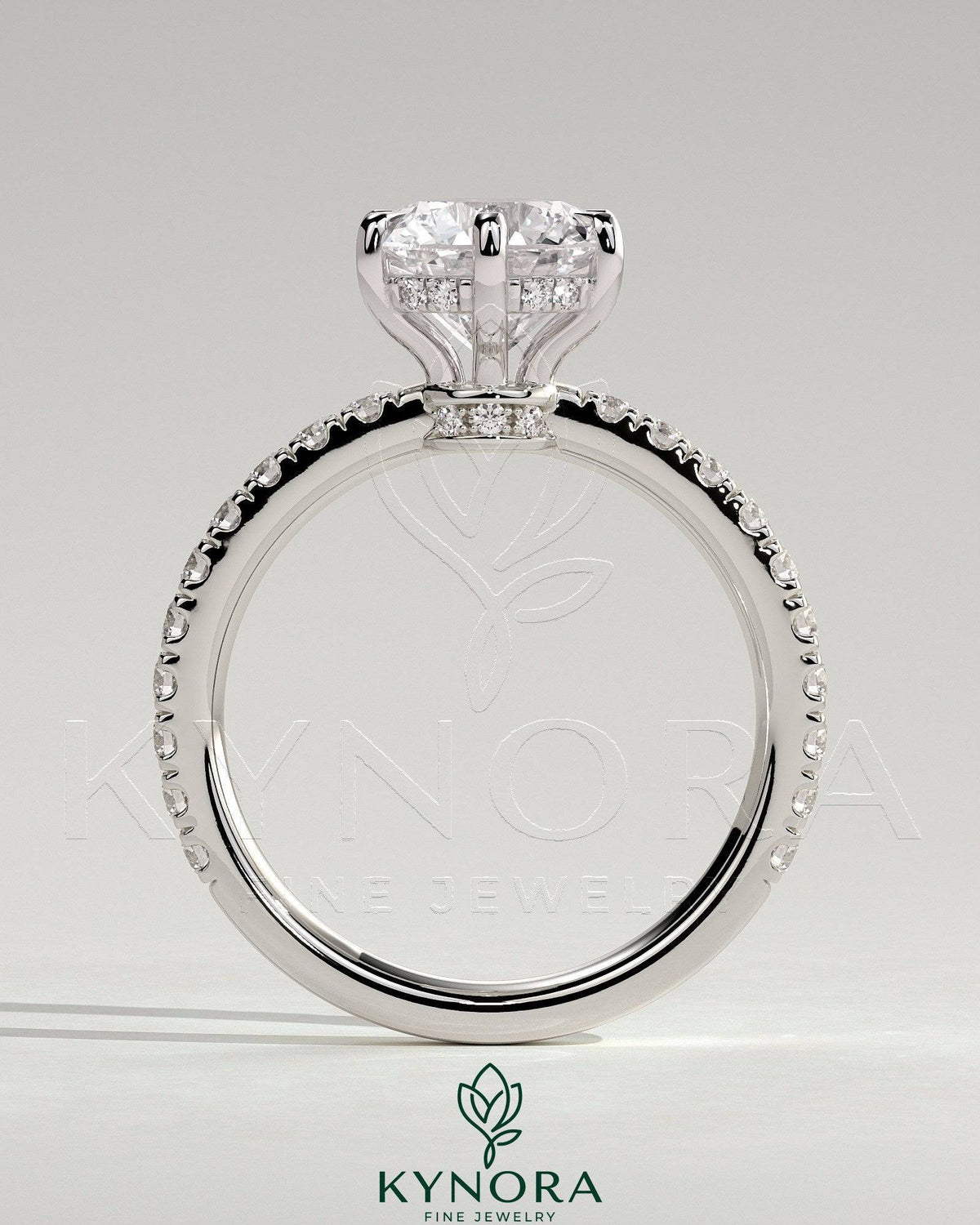 Kynora CJ 2ct round claw solitaire engagement ring with hidden halo, pave collar and band, featuring sparkling diamond details.