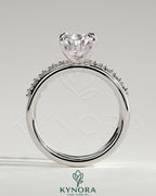 Kynora CJ 2ct pear-shaped diamond solitaire engagement ring with double plain and round accent stones on the band.