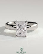 Kynora CJ 2ct radiant diamond claw solitaire engagement ring with cigar band and hidden halo, elegant and sparkling jewelry piece.