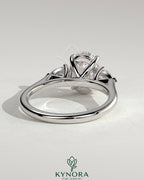 Kynora CJ three stone engagement ring featuring a 2ct oval claw trilogy center stone with pear side stones and cathedral setting.