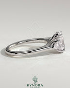 Kynora CJ 2ct oval claw trilogy engagement ring with pear side stones and cathedral setting, showcasing sparkling diamond details.