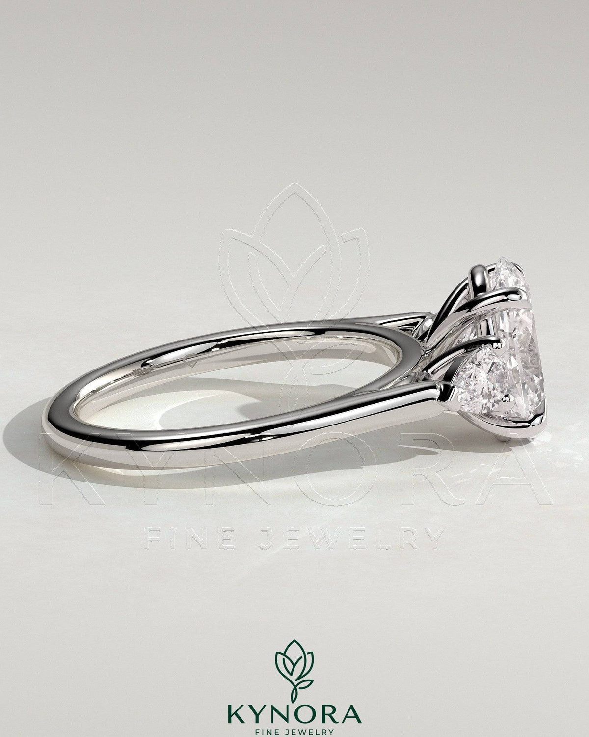 Kynora CJ 2ct oval claw trilogy engagement ring with pear side stones and cathedral setting, showcasing sparkling diamond details.