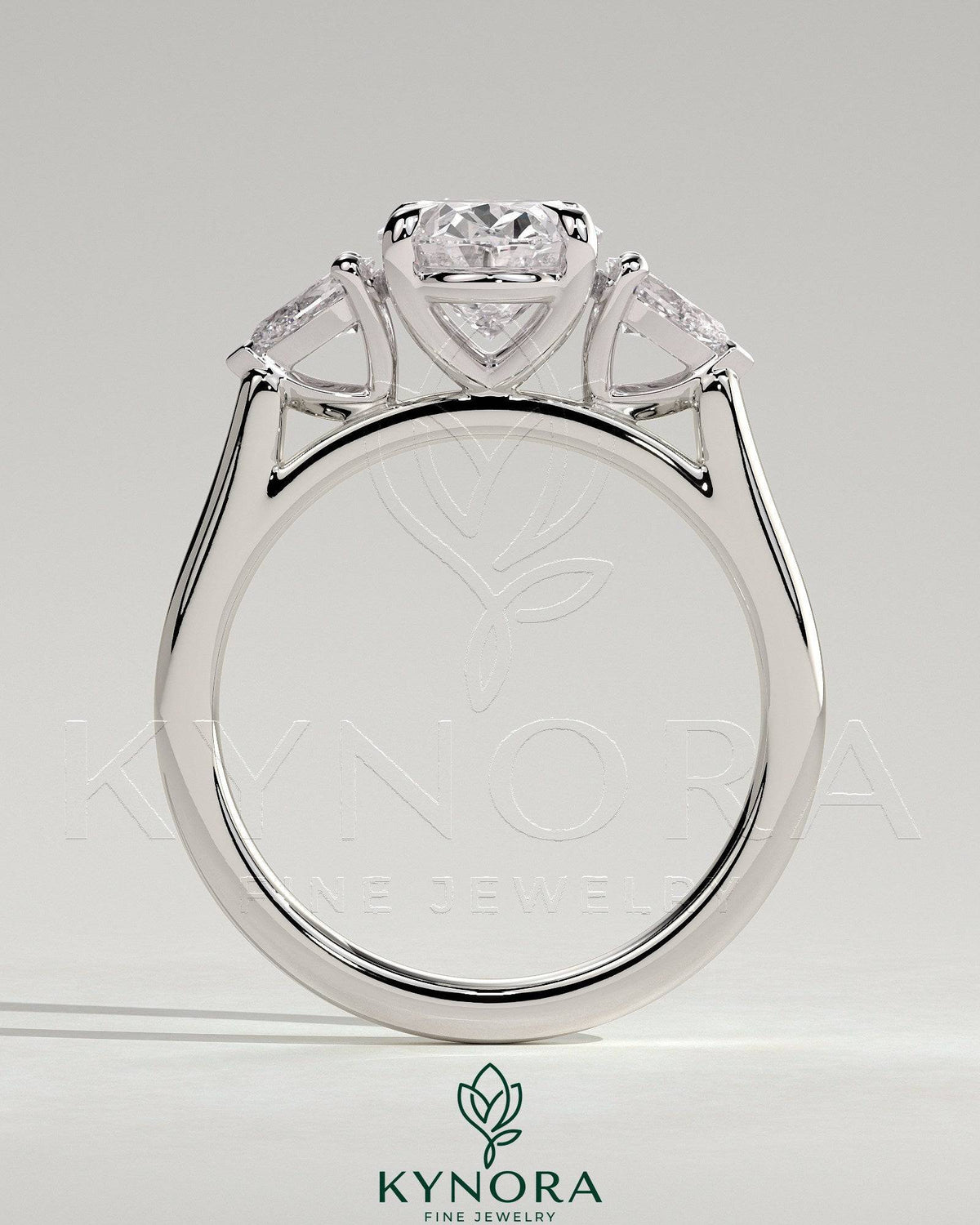 Kynora CJ 2ct oval claw trilogy engagement ring with pear side stones and cathedral setting, showcasing elegant diamond design.