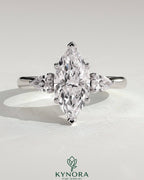 Kynora CJ 2ct marquise claw trilogy engagement ring with pear side stones and hidden halo, showcasing sparkling diamond design.
