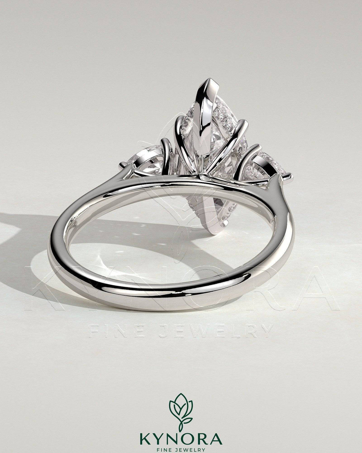 Kynora CJ 2ct marquise claw trilogy engagement ring with pear side stones and hidden halo, crafted in elegant jewelry design.