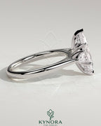 Kynora CJ 2-carat marquise claw trilogy engagement ring with pear side stones and hidden halo, showcasing elegant diamond setting.